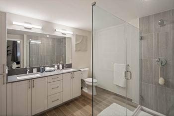 A bathroom with a walk-in shower and double sinks.